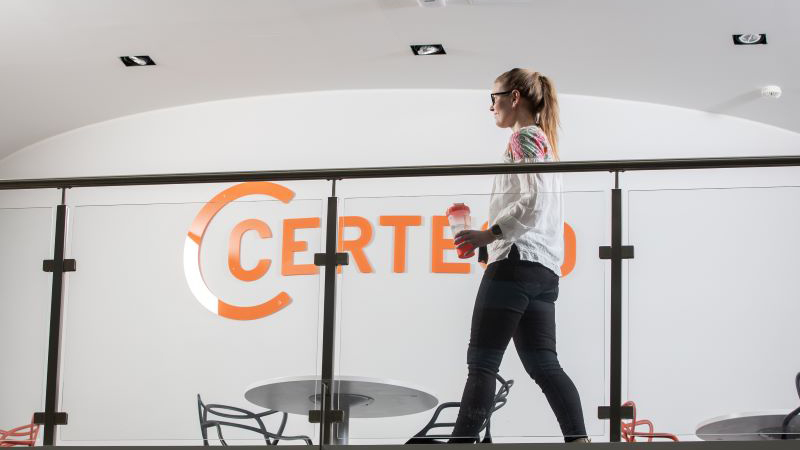 Woman walking past a Certego-sign