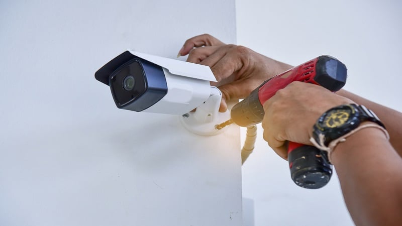 A worker setting up a security camera