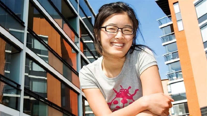 Female student in front of student housing apartmentbuilding.