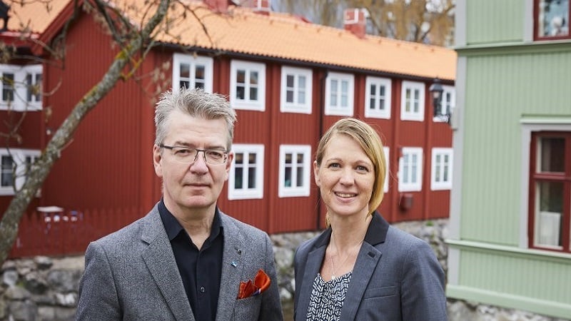 Malin Lampa and Thomas Harry standing in front of a red building.
