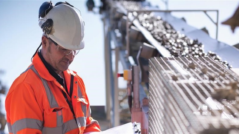 Worker from Certego standing beside a sorting machine.